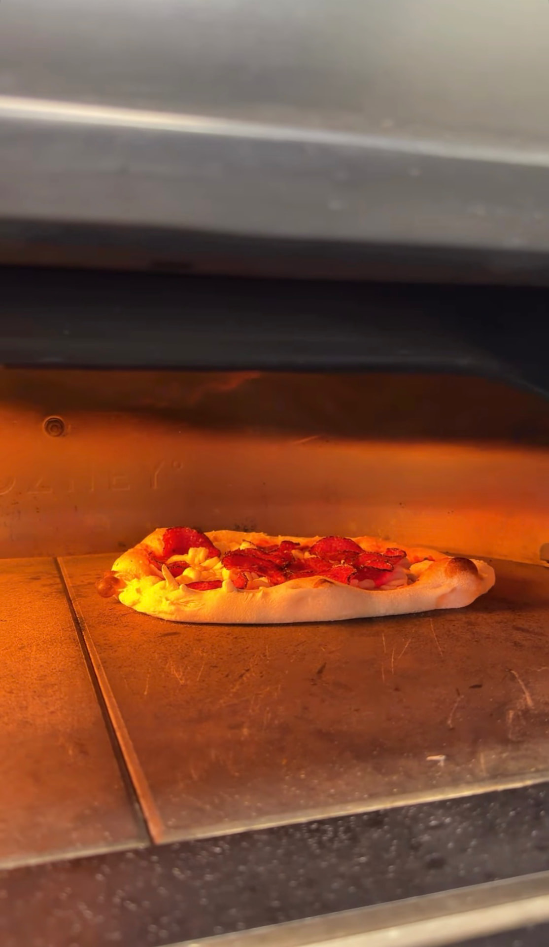 Pepperoni pizza baking inside the stone oven
