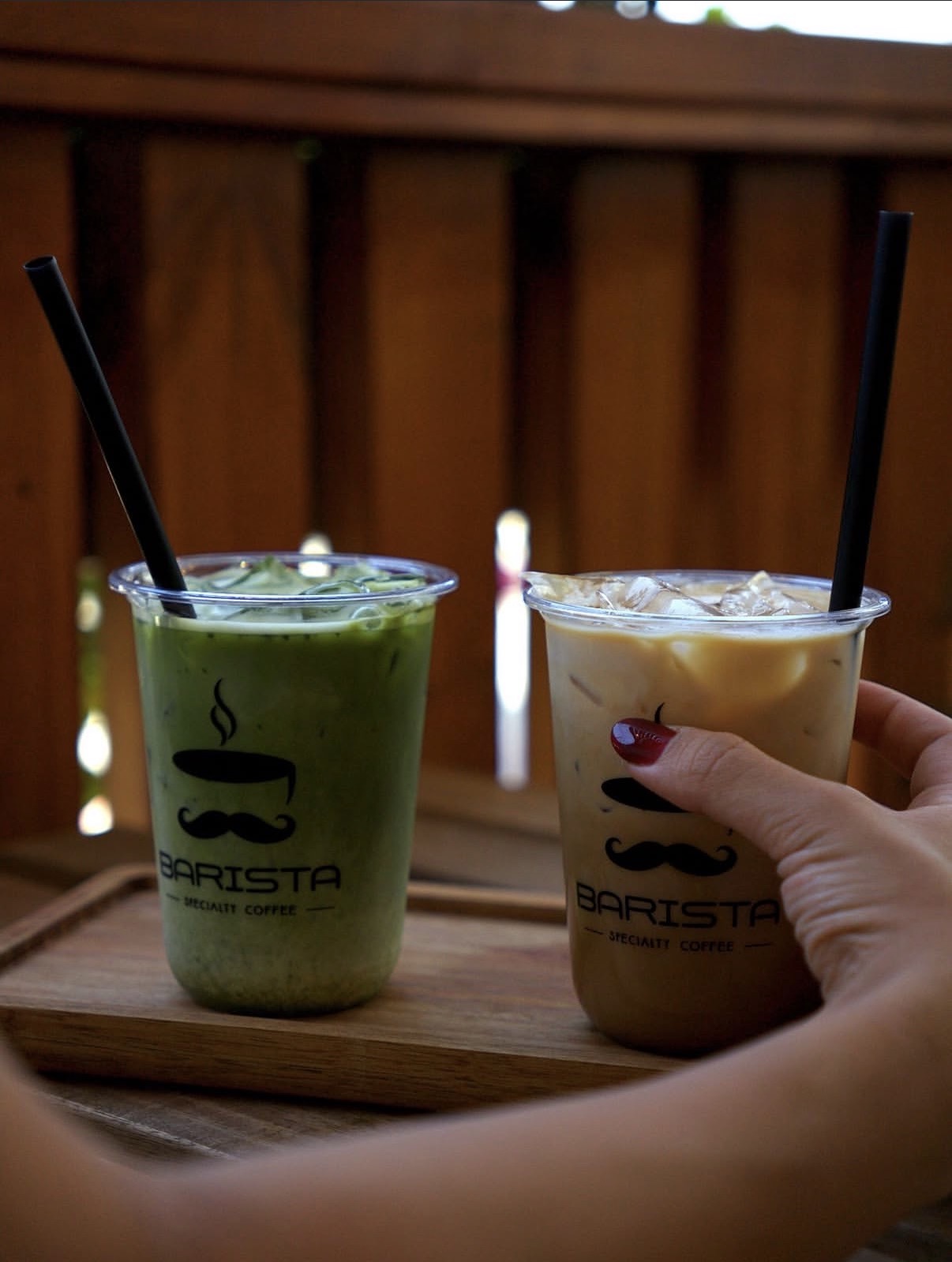 Iced matcha and iced latte served on a wooden tray